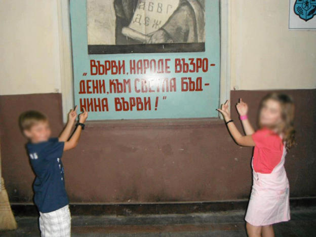 Деца позират със средни пръсти пред азбуката
