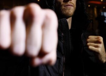 Бракониер млати горски с дърво пред дома му