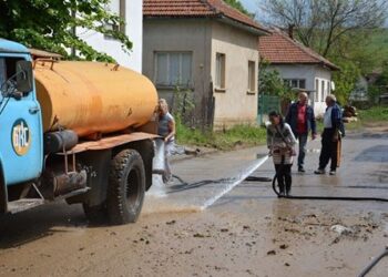 Затворници чистят наводнено село