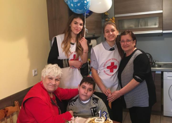 Млади червенокръстци подкрепят дете, приковано в инвалидна количка
