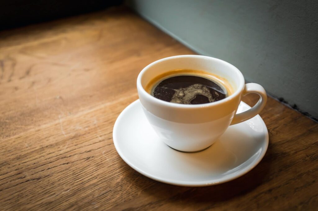 Защо кафето не трябва да се пие прекалено горещо или след 40-а минута? 3 a cup of black coffee on the wooden windowsill