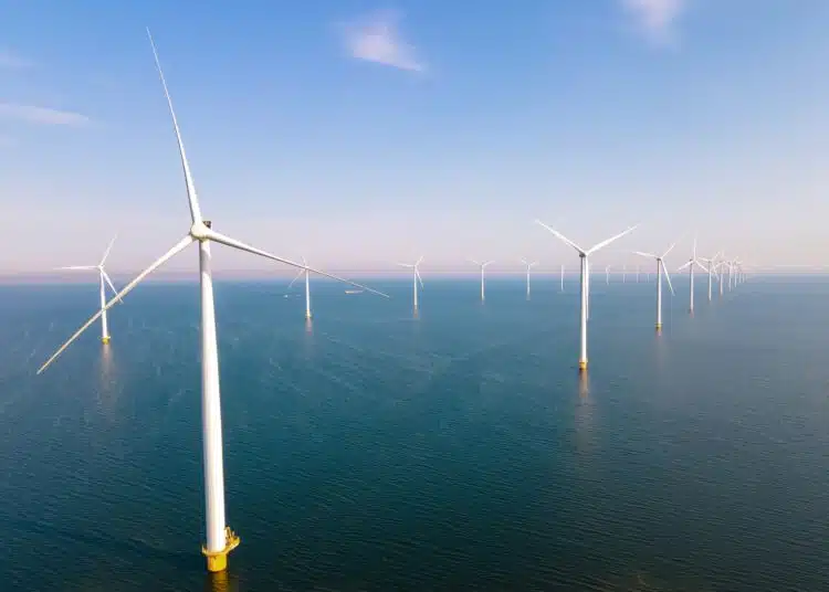 offshore windmill park with clouds and a blue sky