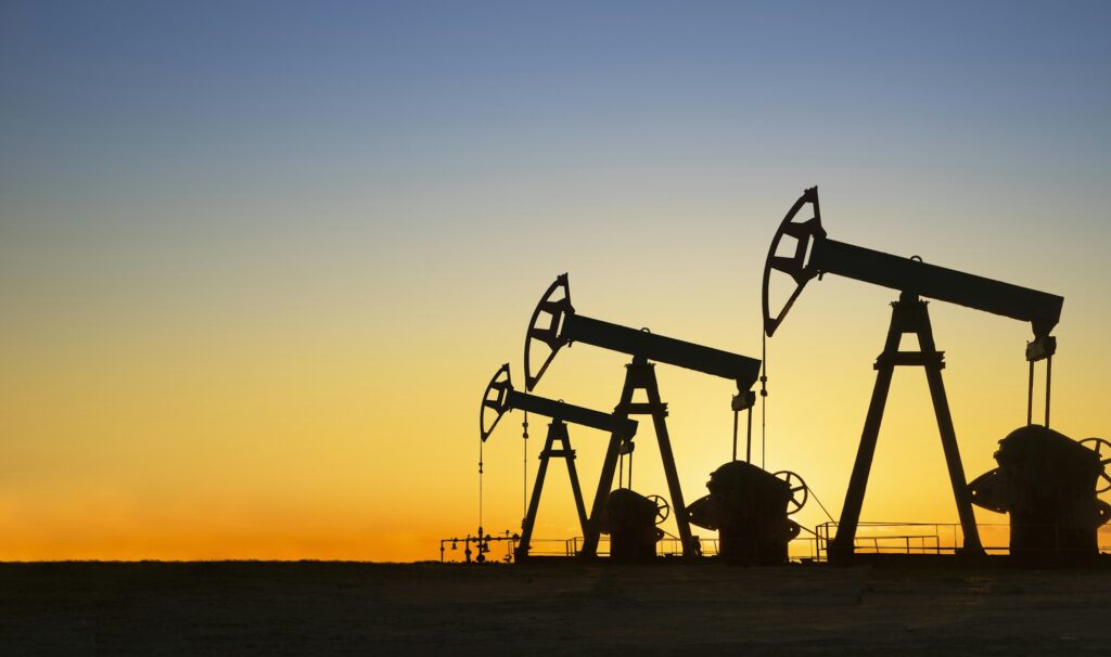 silhouette of oil wells in desert at sunset texas usa