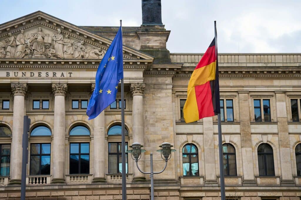 Германия заделя €13,3 млрд. за по-евтина енергия през 2027 г. 2 flags of germany and european union against bundestag building