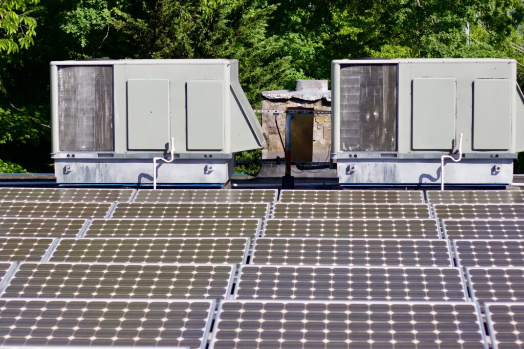 Слънчевата енергия и климатизацията са допълващи се технологии 2 solar panels and hvac units on building roof 2026 03 11 00 50 53 utc scaled 1