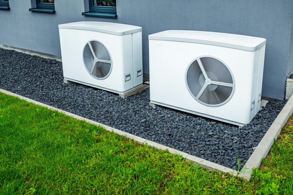 two air source heat pumps installed outside of new and modern city house green renewable energy
