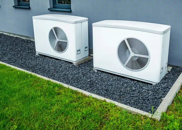 two air source heat pumps installed outside of new and modern city house green renewable energy